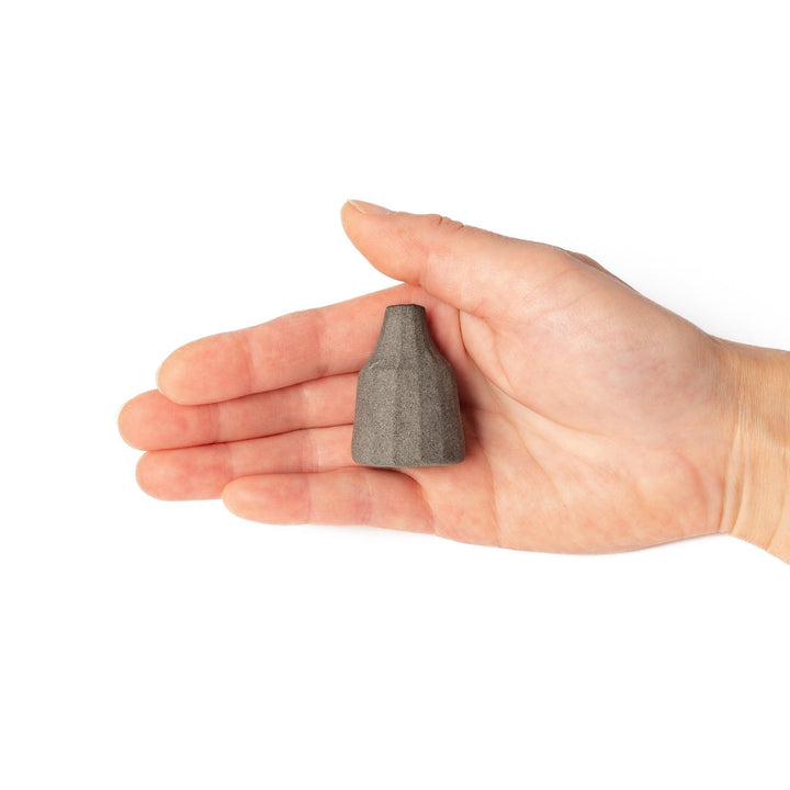 Minimalist dark ceramic bud vase with a faceted prism-like form and matte texture, ideal for adding a sculptural touch to small arrangements.