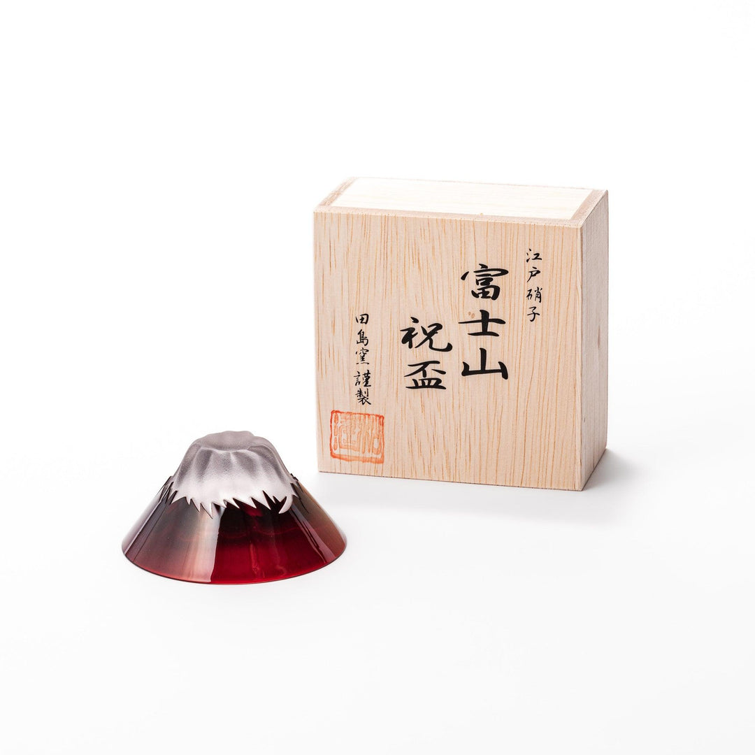 Red glass sake cup in the form of Mount Fuji, complete with a frosted snowcap design, crafted for elegant Japanese-style celebrations.