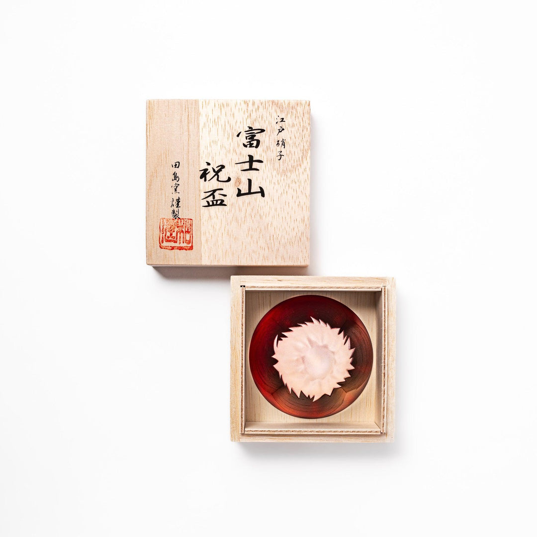 Red glass sake cup in the form of Mount Fuji, complete with a frosted snowcap design, crafted for elegant Japanese-style celebrations.