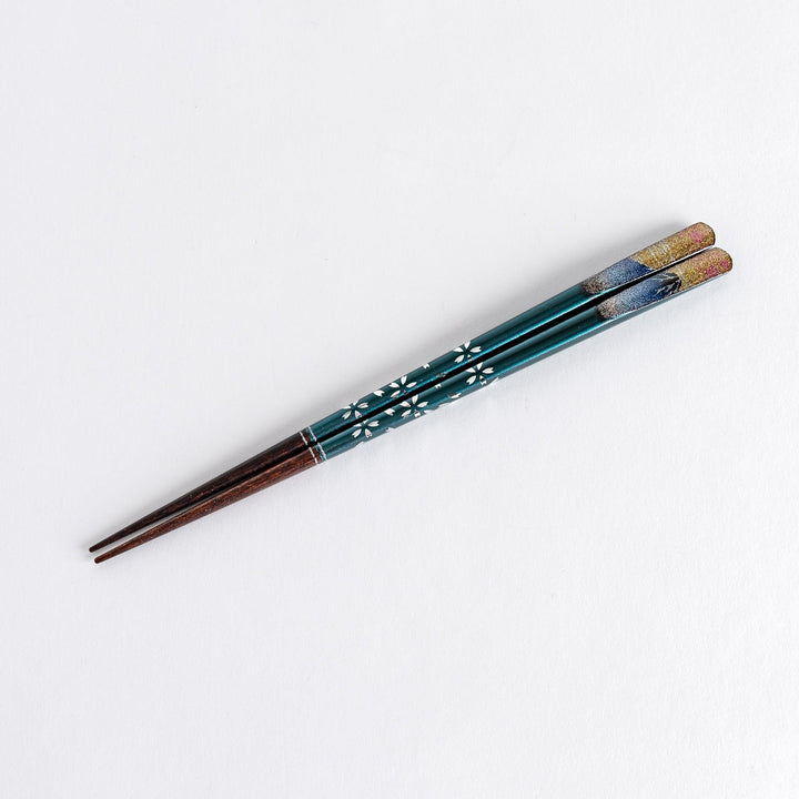 A boxed set of two pairs of chopsticks, one with blue and one with red handles, featuring Mount Fuji designs.