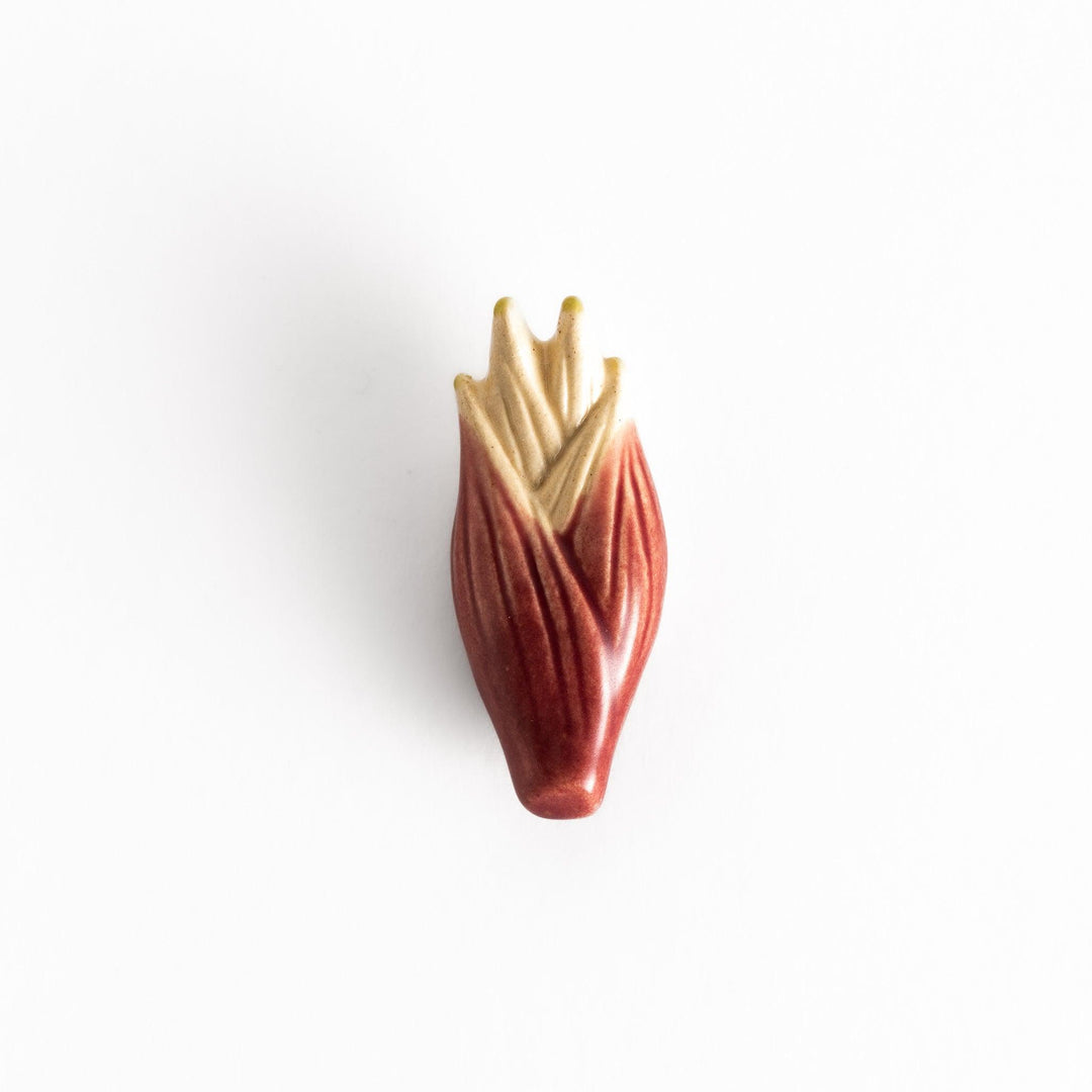 Glossy ceramic myoga ginger-shaped chopstick rest in soft red with beige tones, elegantly crafted for a unique table setting.