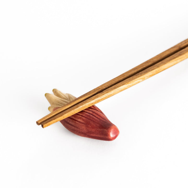 Wooden chopsticks balanced on the ceramic myoga ginger chopstick rest, showcasing its sturdy, practical design and refined aesthetic.