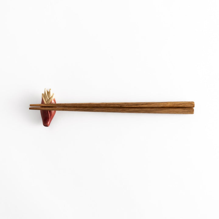 Wooden chopsticks balanced on the ceramic myoga ginger chopstick rest, showcasing its sturdy, practical design and refined aesthetic.