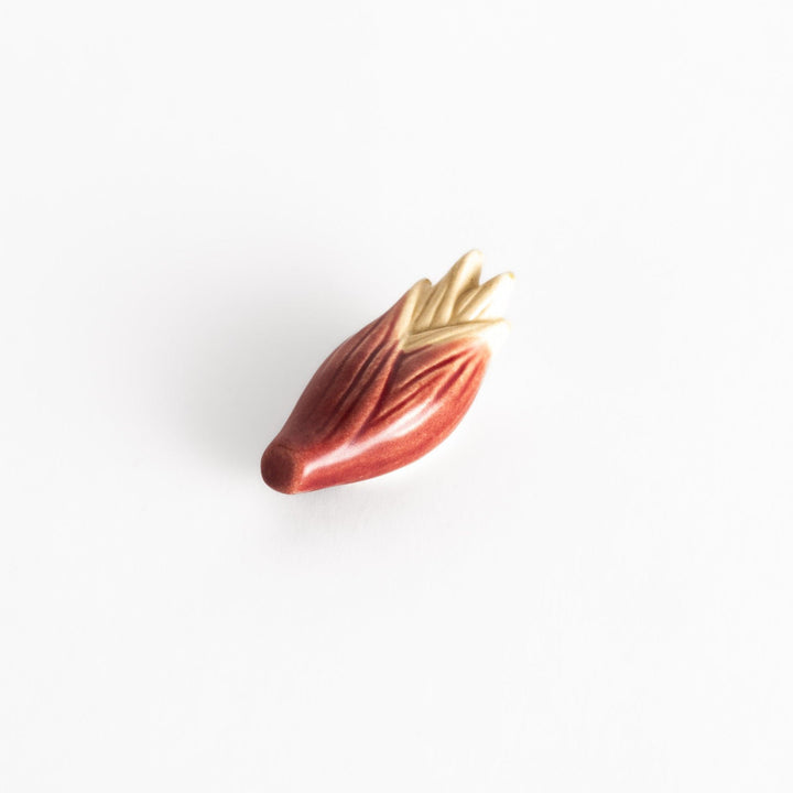 Glossy ceramic myoga ginger-shaped chopstick rest in soft red with beige tones, elegantly crafted for a unique table setting.