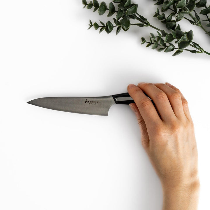 A Nagomi Professional utility knife with a sleek, sharp blade and a modern striped handle, offering precision and comfort for all your kitchen tasks.