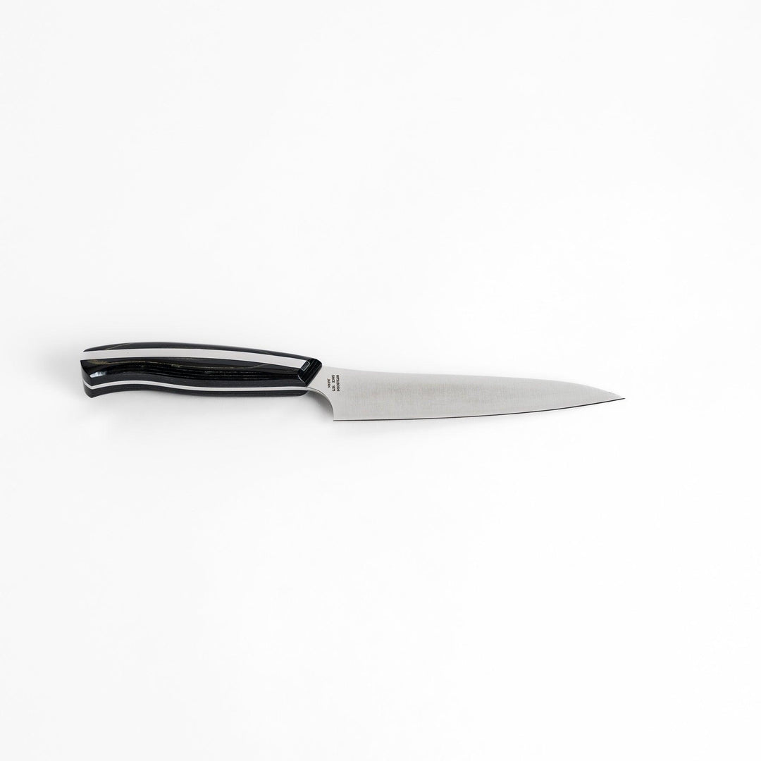 A Nagomi Professional utility knife with a sleek, sharp blade and a modern striped handle, offering precision and comfort for all your kitchen tasks.
