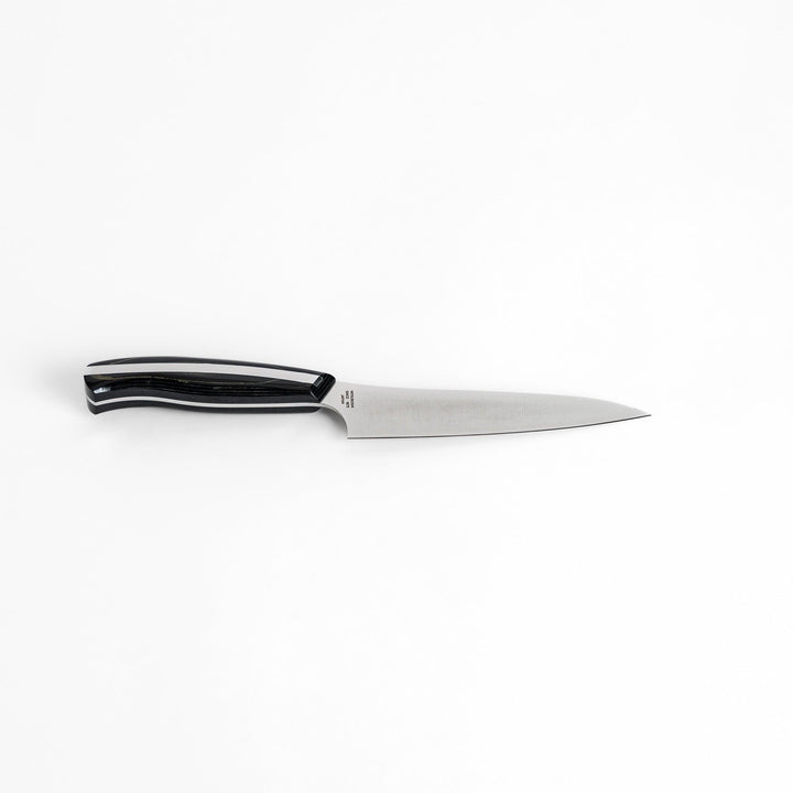 A Nagomi Professional utility knife with a sleek, sharp blade and a modern striped handle, offering precision and comfort for all your kitchen tasks.
