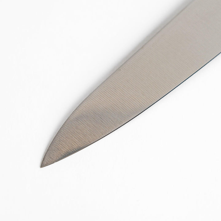 A Nagomi utility knife featuring a sharp, durable blade and a beautifully crafted striped wooden handle, designed for precision and comfort in various kitchen tasks.
