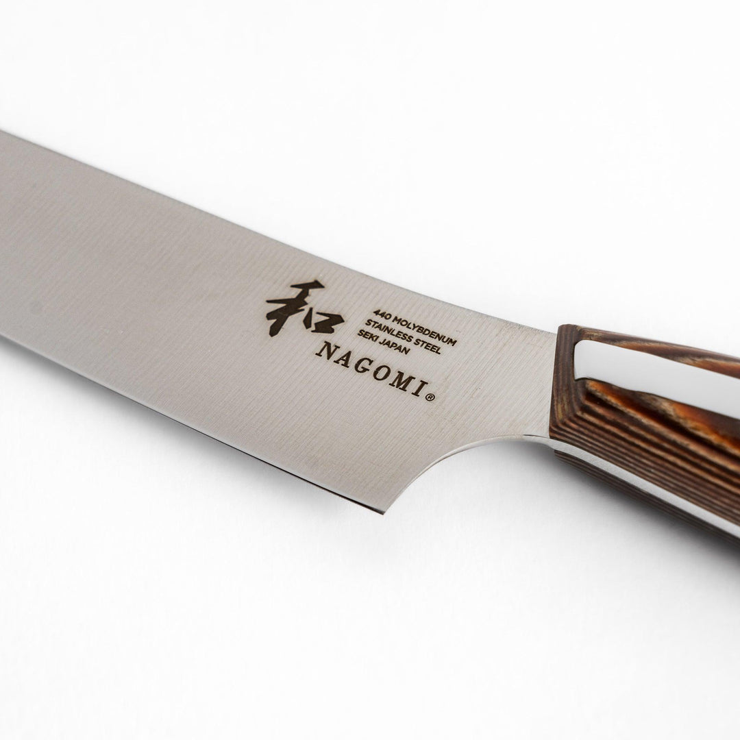 A Nagomi utility knife featuring a sharp, durable blade and a beautifully crafted striped wooden handle, designed for precision and comfort in various kitchen tasks.