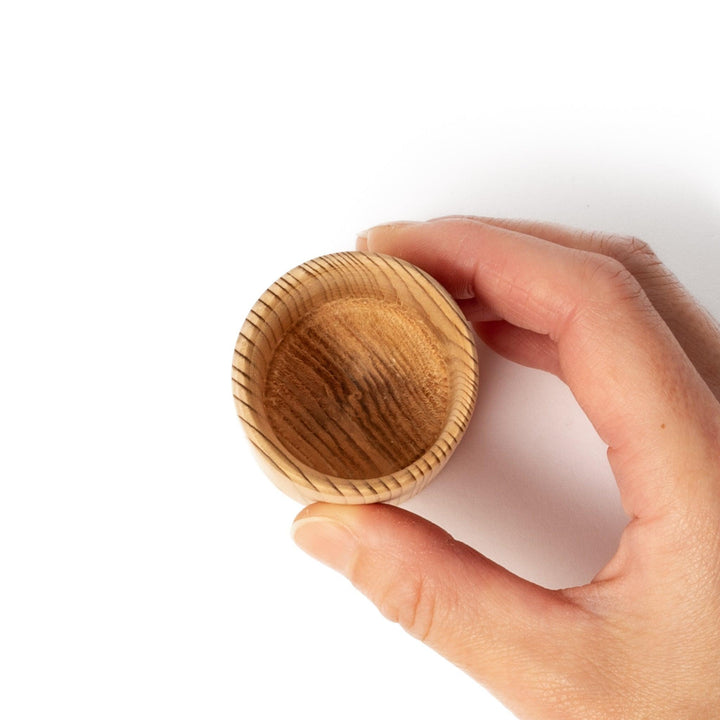 Natural cedar sake cup with a smooth curved rim and vertical grain lines, offering a warm, aromatic touch to your traditional Japanese drinkware.
