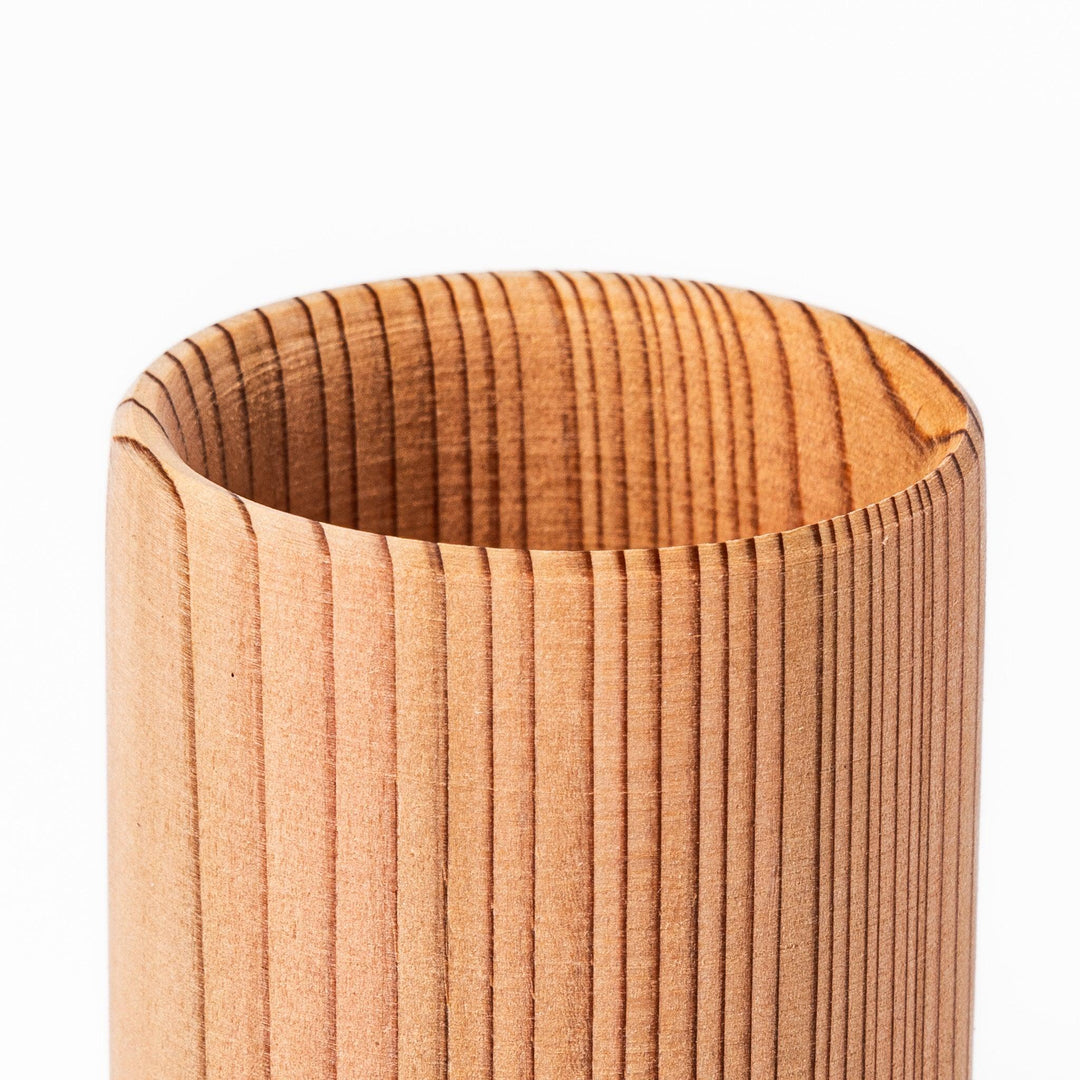 Natural cedar sake cup with a smooth curved rim and vertical grain lines, offering a warm, aromatic touch to your traditional Japanese drinkware.