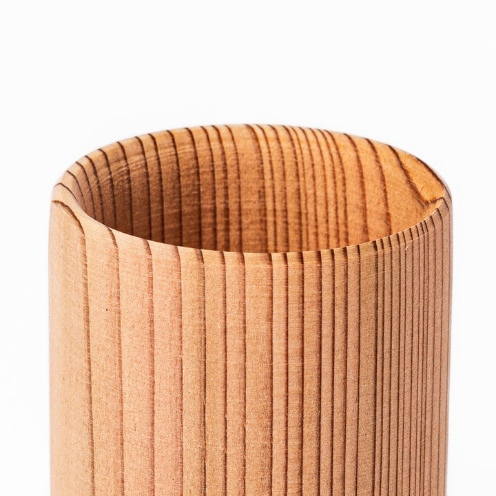 Natural cedar sake cup with a smooth curved rim and vertical grain lines, offering a warm, aromatic touch to your traditional Japanese drinkware.