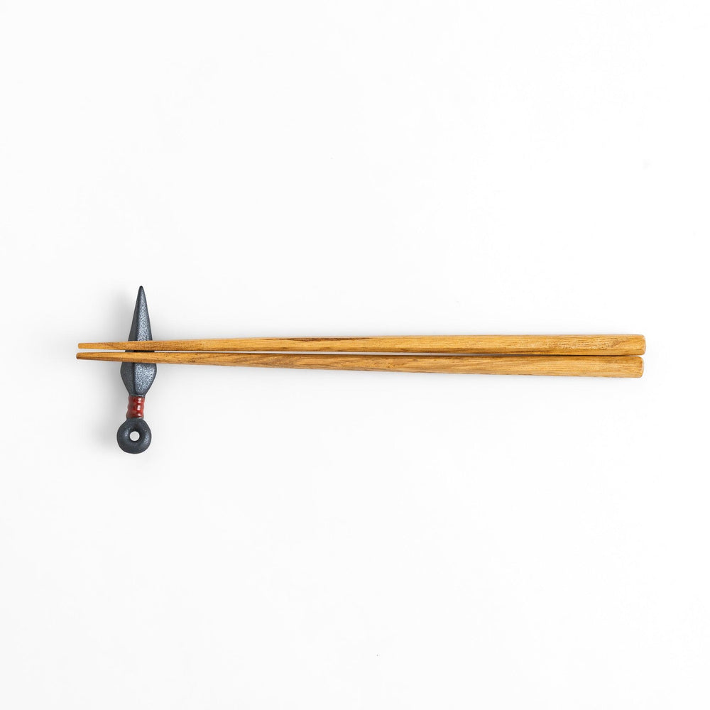Sleek ninja blade-shaped chopstick rest with a metallic finish and red accent, adding a bold and unique touch to your dining experience.