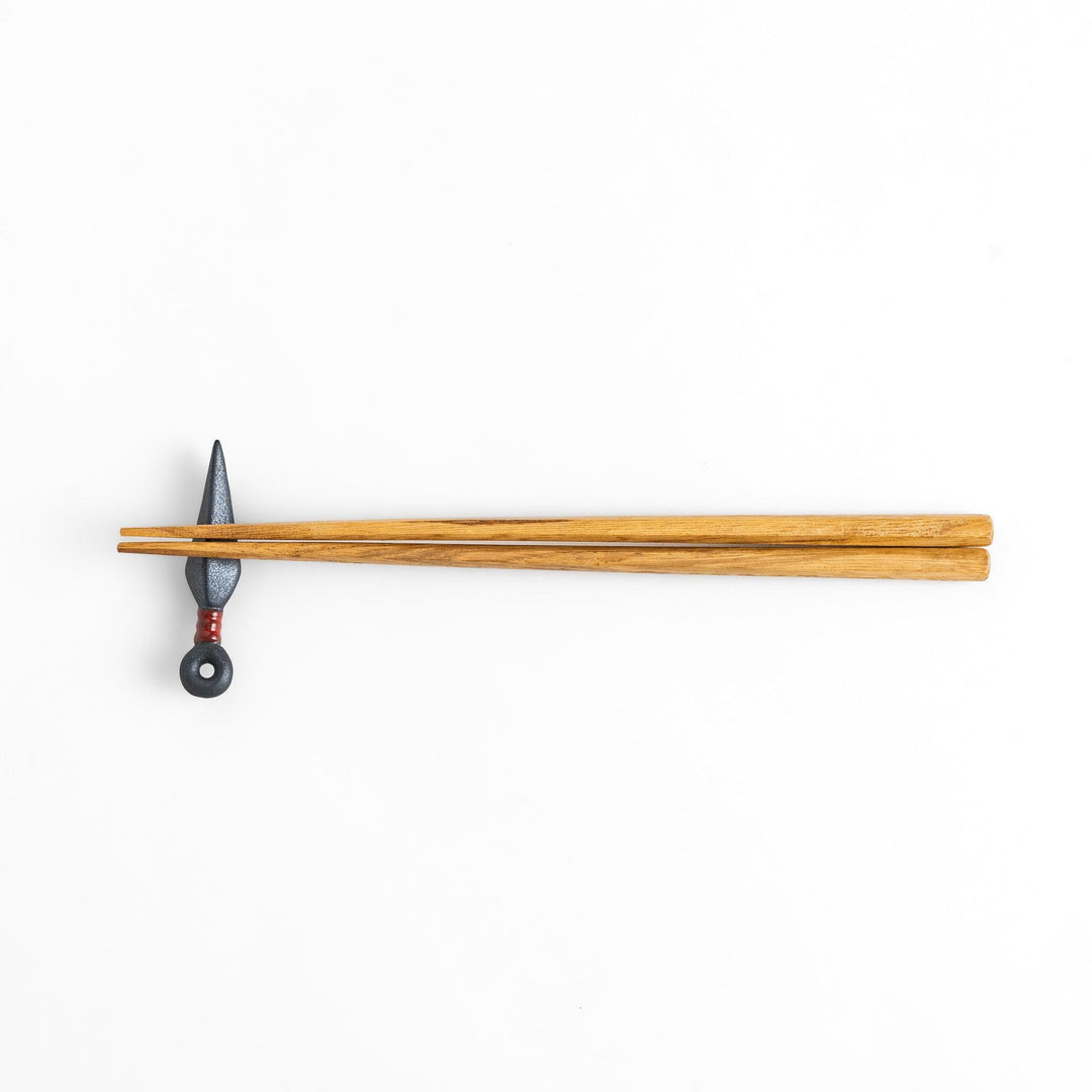 Sleek ninja blade-shaped chopstick rest with a metallic finish and red accent, adding a bold and unique touch to your dining experience.