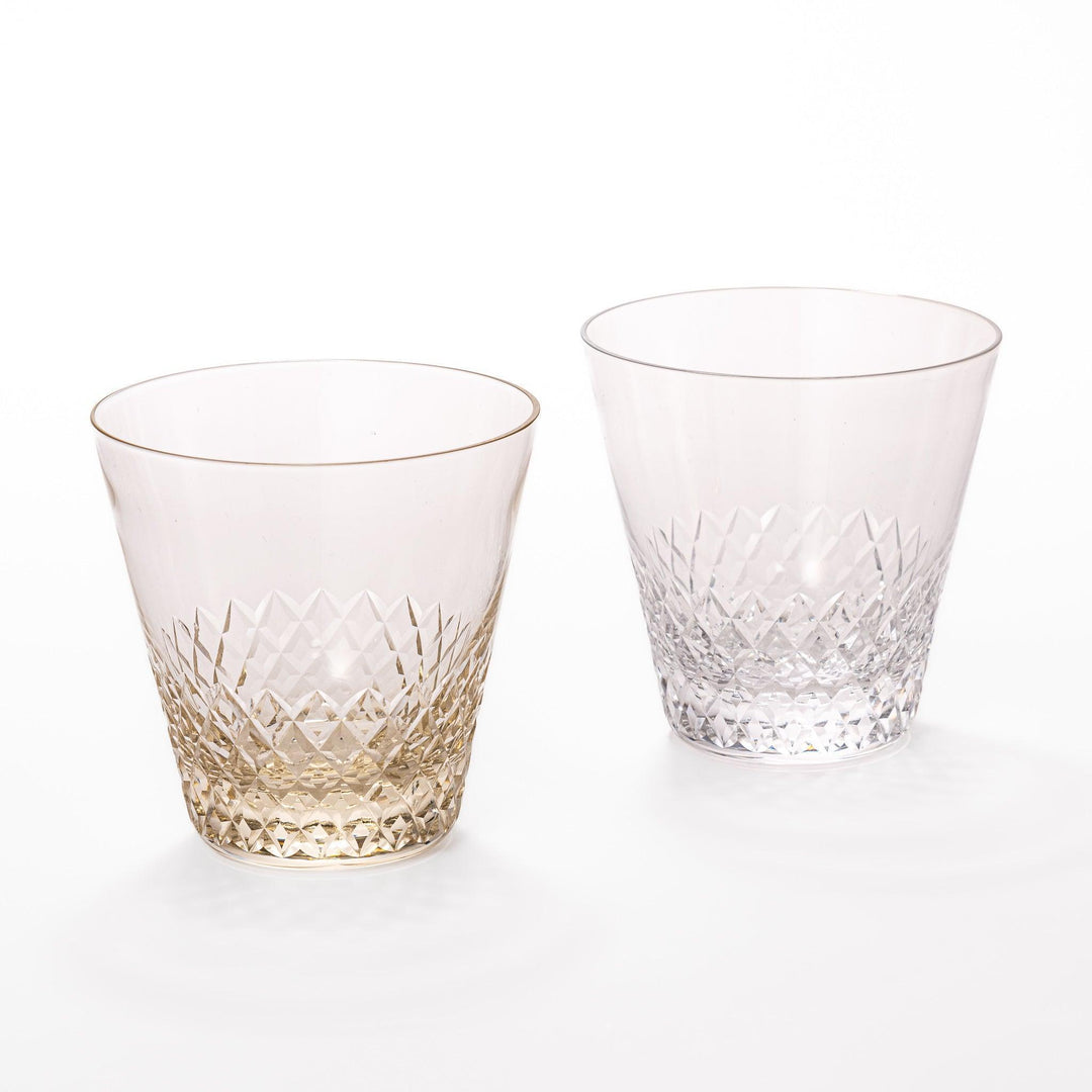 Pair of textured nostalgia rocks glasses in amber and clear with diamond-cut pattern near base, ideal for whisky or cocktails.