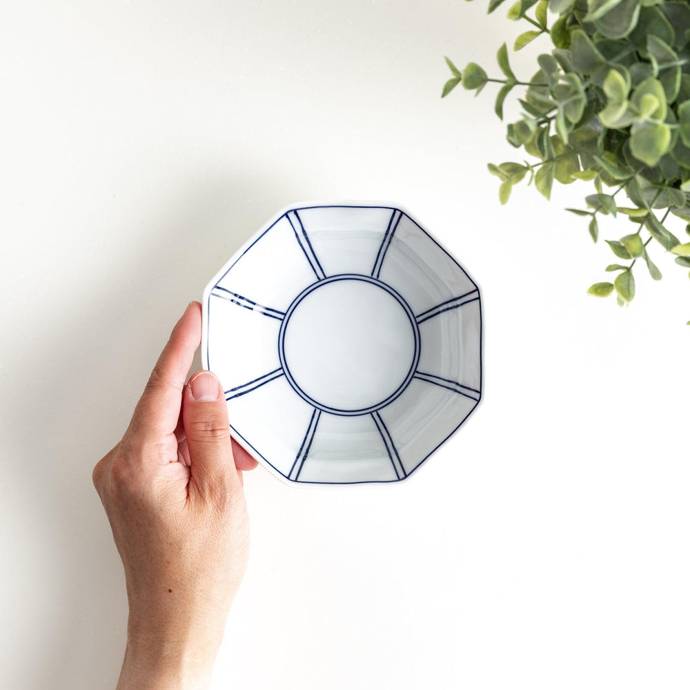 Small, white octagonal dessert bowls with thin blue and red lines forming geometric patterns.