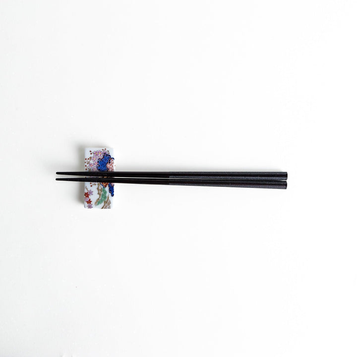 Octagonal wooden chopsticks with a brown tone, finished with a textured grain. Available in red or black.