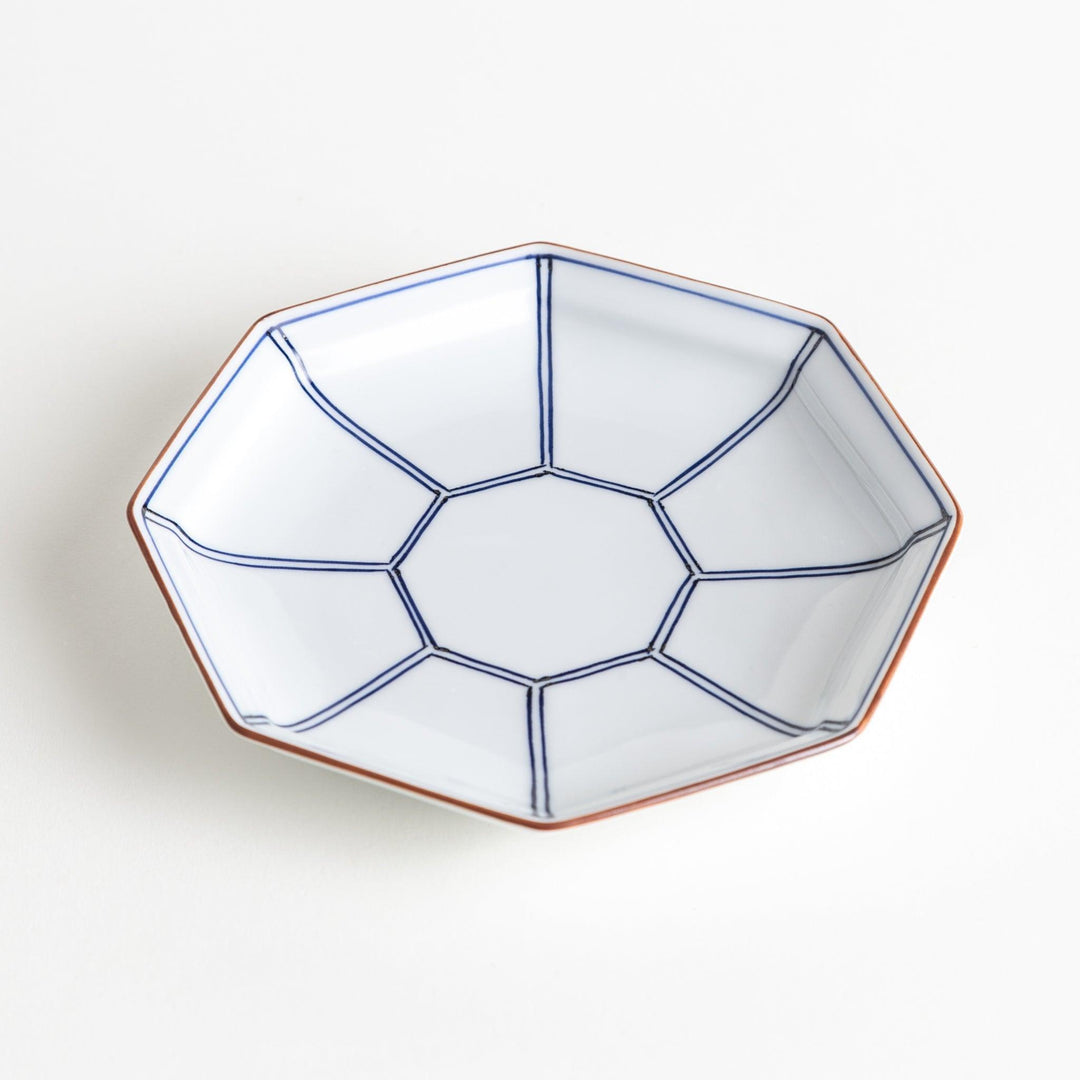 An octagonal porcelain dessert plate with a minimalist grid pattern.