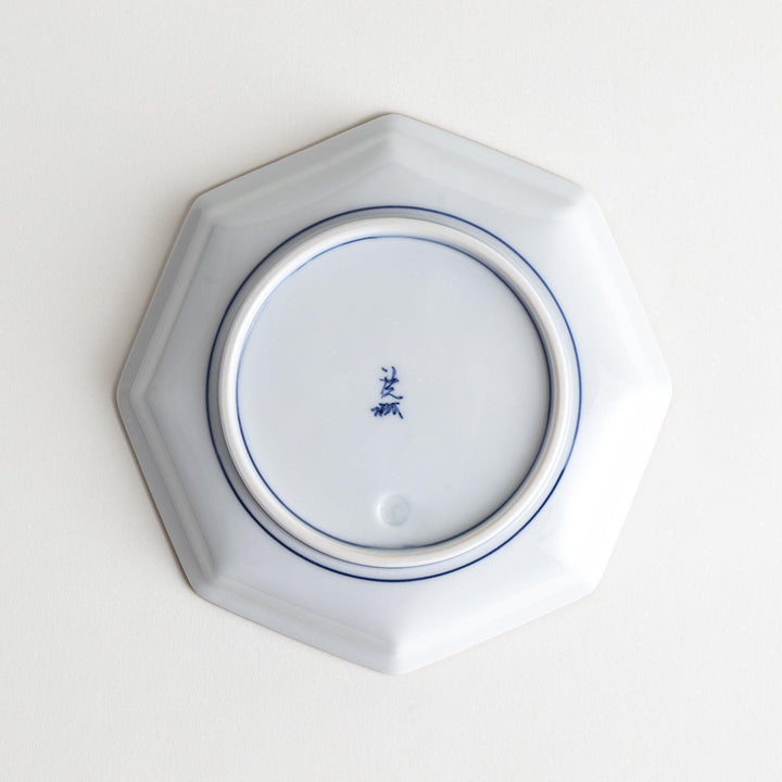An octagonal porcelain dessert plate with a minimalist grid pattern.