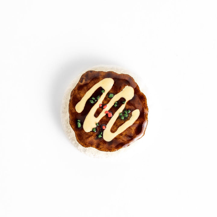Fun Okonomiyaki-shaped chopstick rest with realistic details, including drizzled sauce and colorful toppings.
