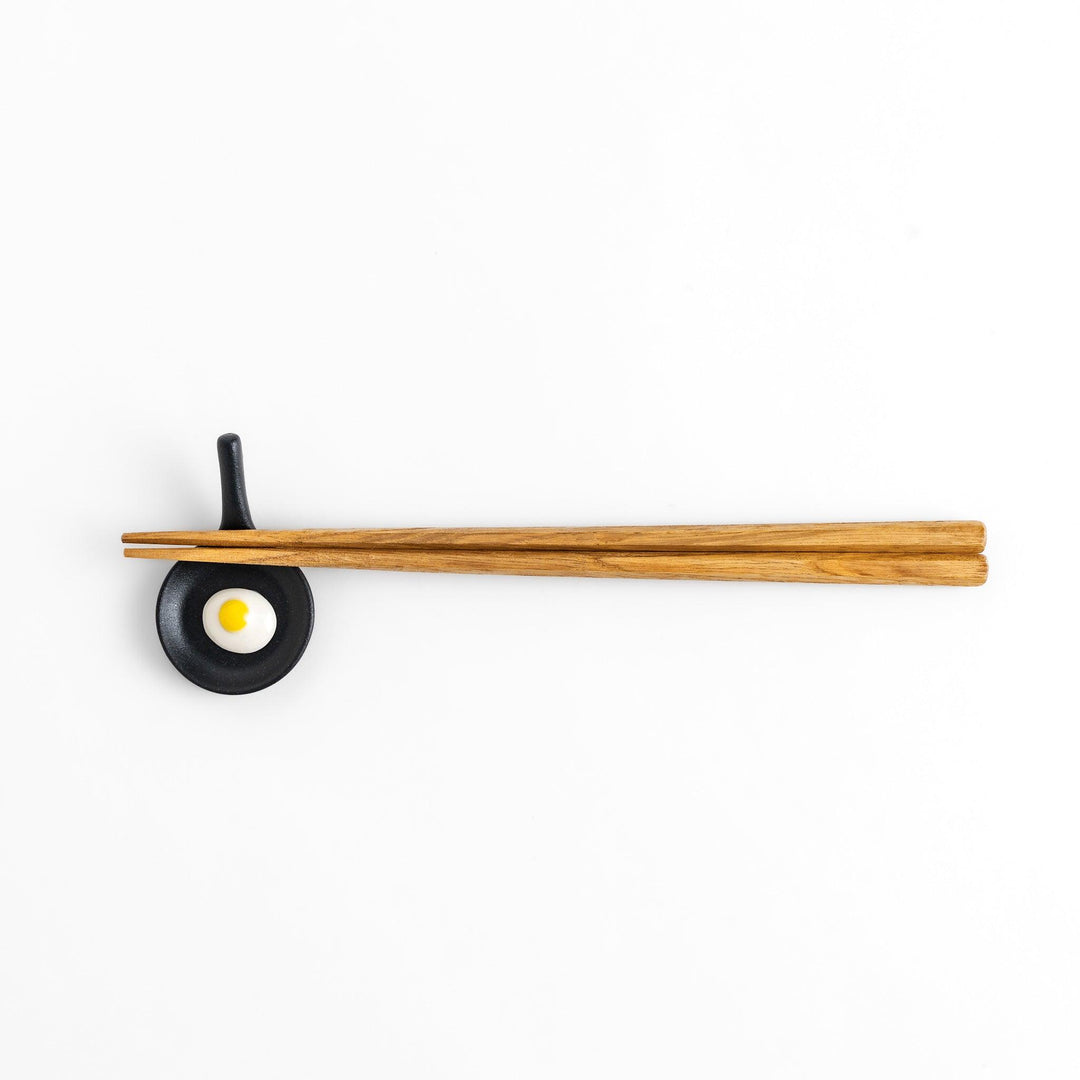 Chopstick rest shaped like a frying pan with a realistic fried egg design, adding a fun and playful touch to your dining experience.