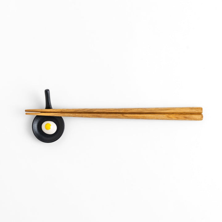 Chopstick rest shaped like a frying pan with a realistic fried egg design, adding a fun and playful touch to your dining experience.