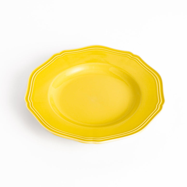 Pretty yellow dessert plate with a delicate scalloped edge, ideal for showcasing your favorite treats.