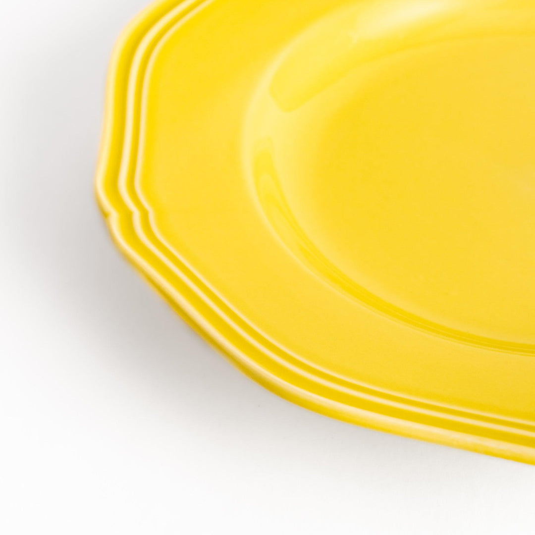 Pretty yellow dessert plate with a delicate scalloped edge, ideal for showcasing your favorite treats.