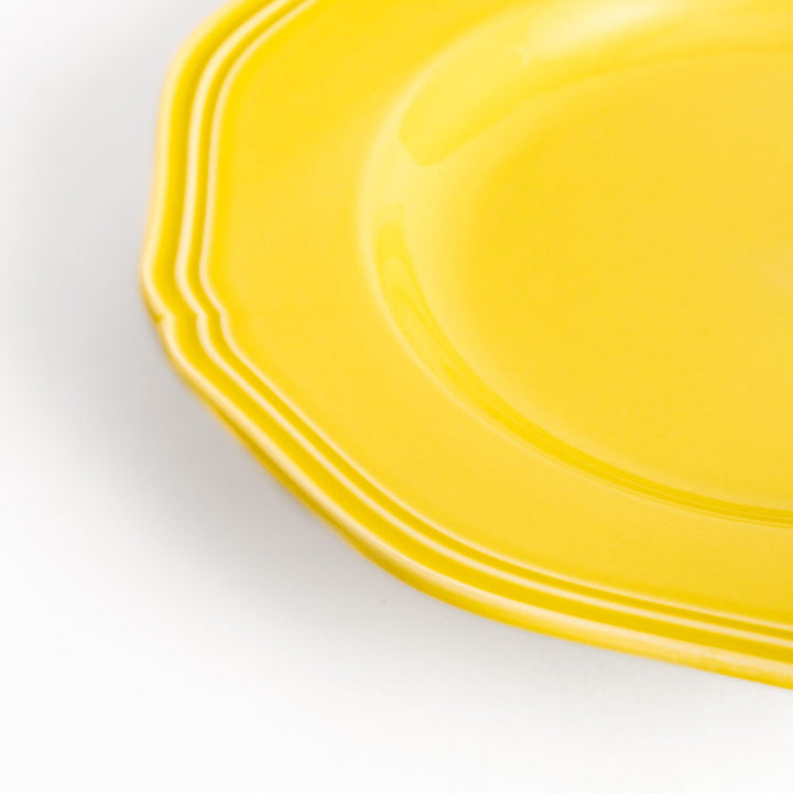 Pretty yellow dessert plate with a delicate scalloped edge, ideal for showcasing your favorite treats.