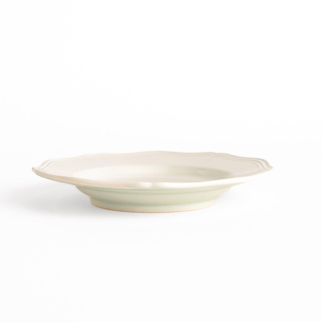 Pretty white dessert plate with a delicate scalloped edge, ideal for showcasing your favorite treats.