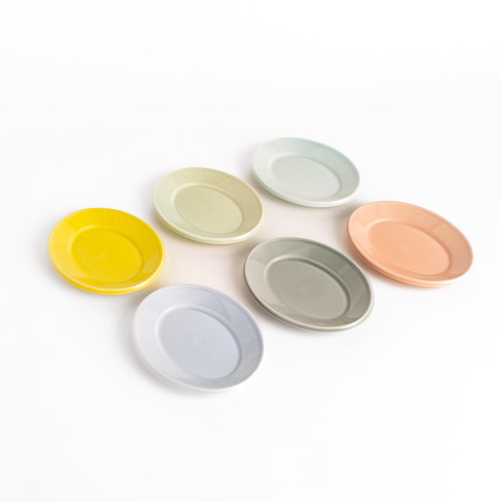 Six pastel-colored oval dessert plates in pink, blue, yellow, green, white, and gray, each with a smooth, glossy finish, perfect for adding a soft, serene touch to your table setting.