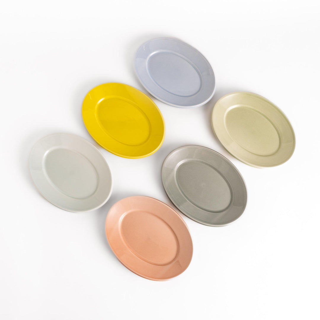Six pastel-colored oval salad plates in pink, blue, yellow, green, white, and gray, each with a smooth, glossy finish, perfect for adding a soft, serene touch to your table setting.