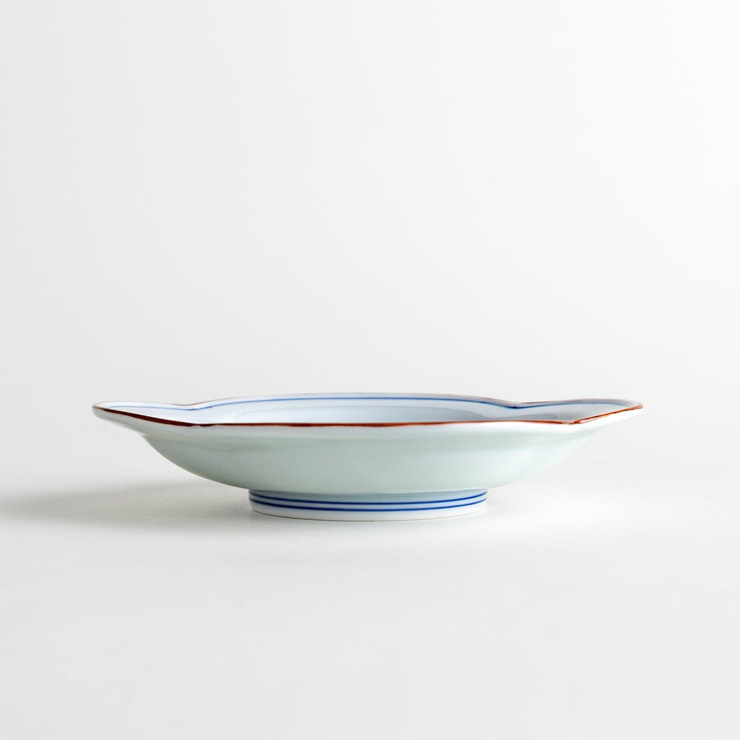 A blue and white porcelain dish with a floral motif in the center, shaped like a cloud.