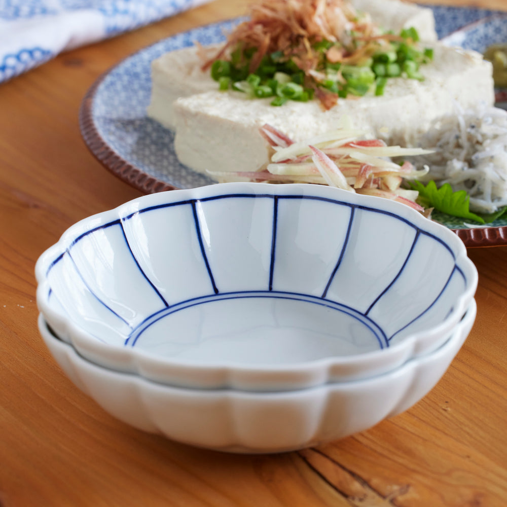 Stacked white porcelain bowls with delicate blue lines showcasing Japanese minimalist design and timeless elegance for serving tofu or side dishes.