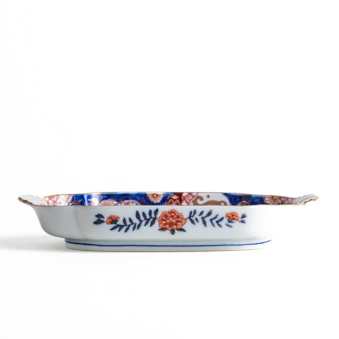 A rectangular salad plate with handles, decorated with scenes of cranes and trees in a traditional Japanese style, bordered by intricate red, blue, and gold patterns.