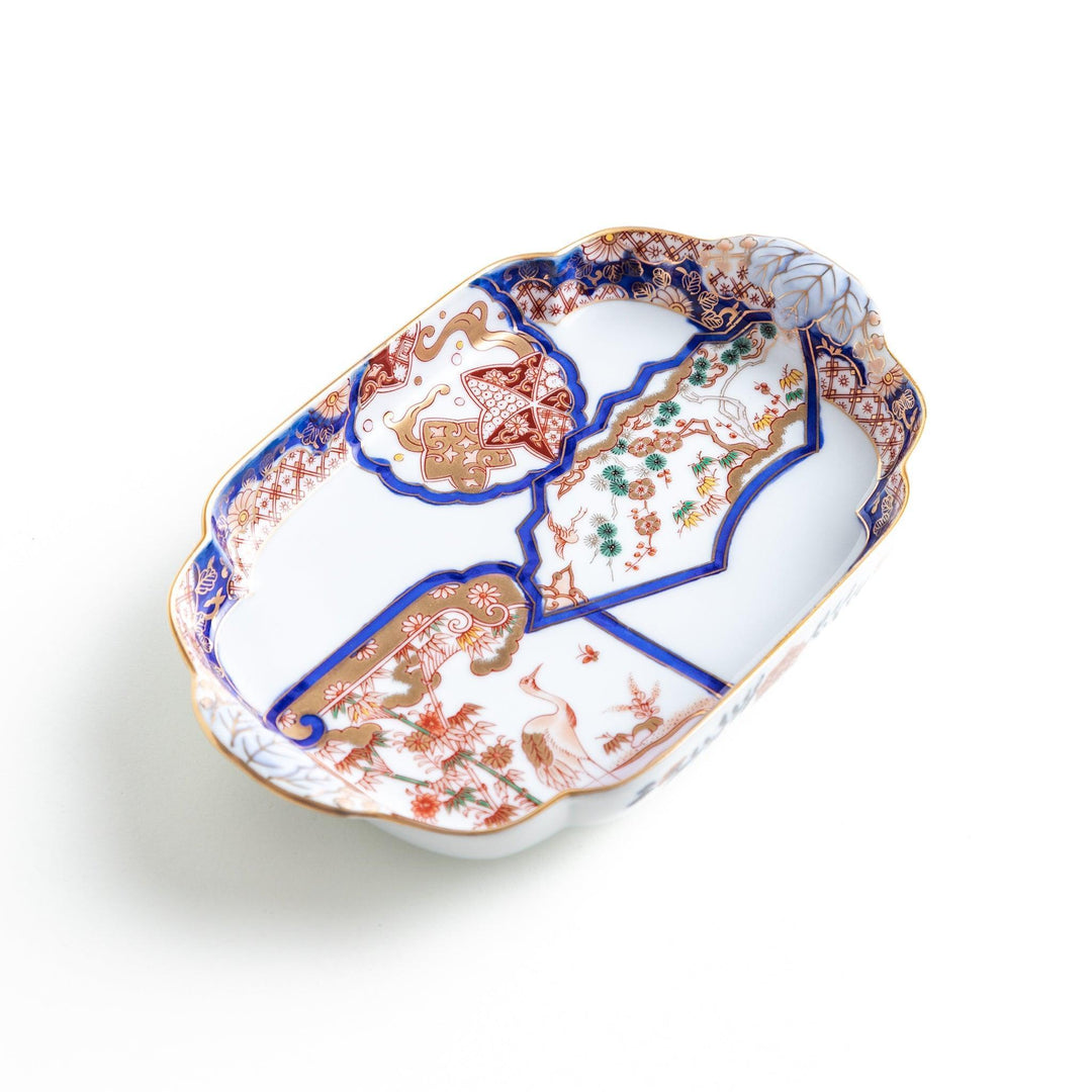 A rectangular salad plate with handles, decorated with scenes of cranes and trees in a traditional Japanese style, bordered by intricate red, blue, and gold patterns.
