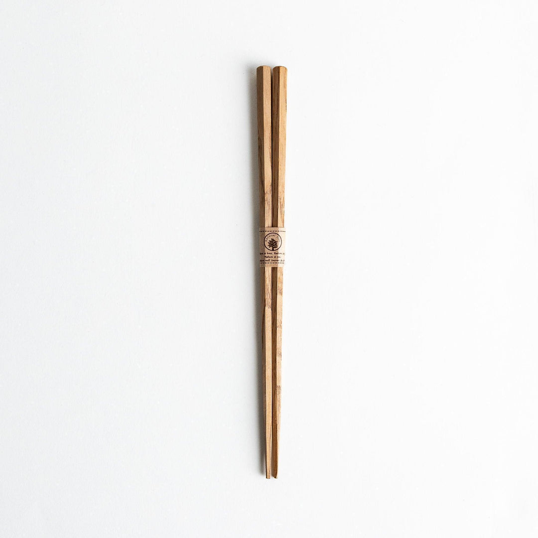 Three pairs of natural chestnut wood chopsticks, each with a different geometric shape—triangle, hexagon, and round.