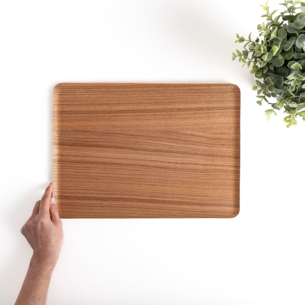 Hand holding a rectangular wooden tray with a beautiful wood grain, a versatile serveware piece for serving food, drinks, or displaying decorative items.
