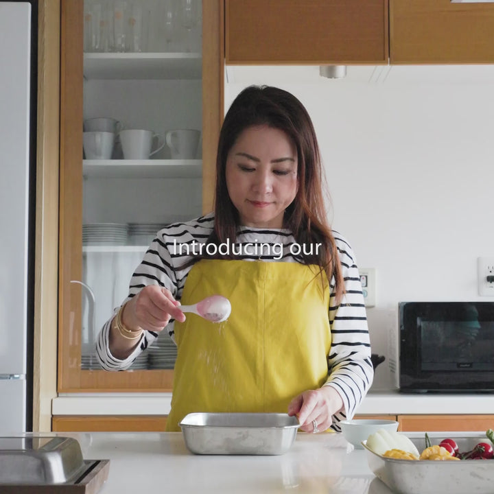 Sprinkling spices onto raw meat with a maraca shaped spice sifter kitchen cooking utensil