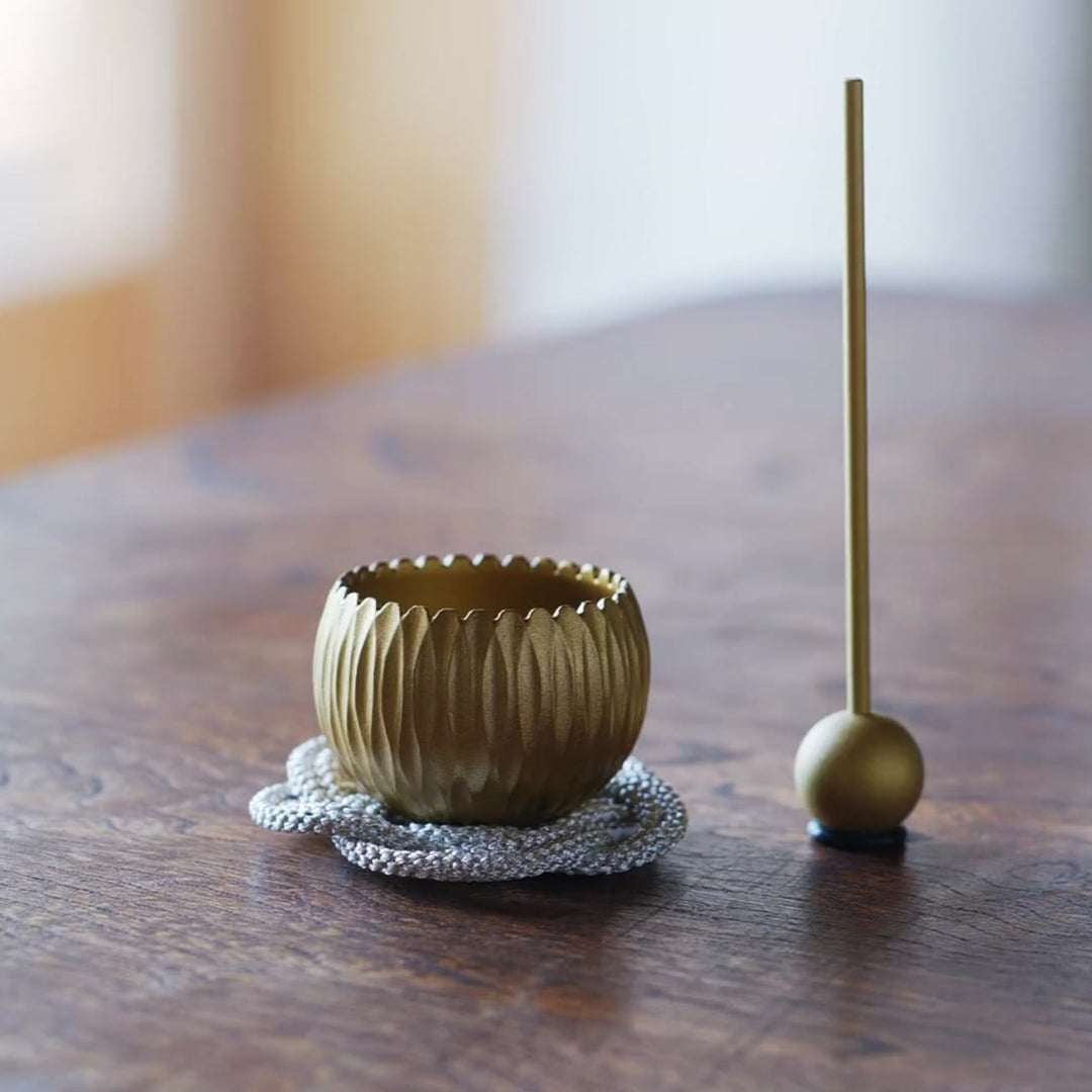 A Japanese brass prayer and meditation bowl decorated with hydrangea motifs, gently played with a mallet.