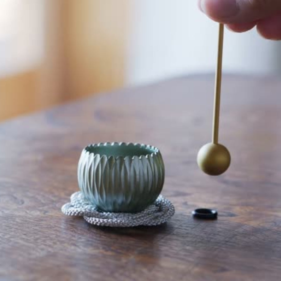 A Japanese brass prayer and meditation bowl decorated with hydrangea motifs, gently played with a mallet.