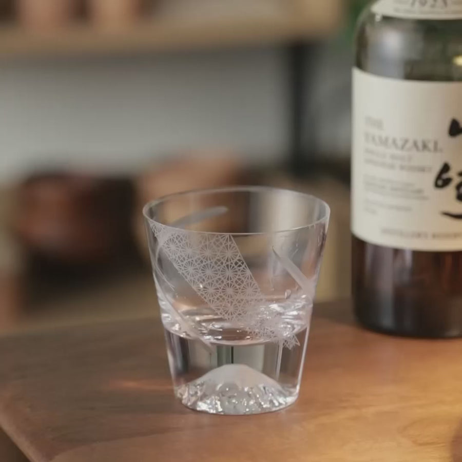 A video showing the Tajima Whiskey Cup with whiskey and ice, where light highlights Mt. Fuji’s peak, showcasing the hand-carved design.
