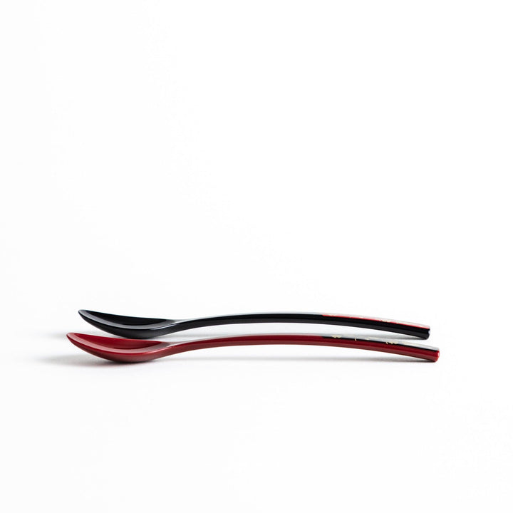 A set of two coffee spoons, one red and one black, with gold floral designs on the handles.