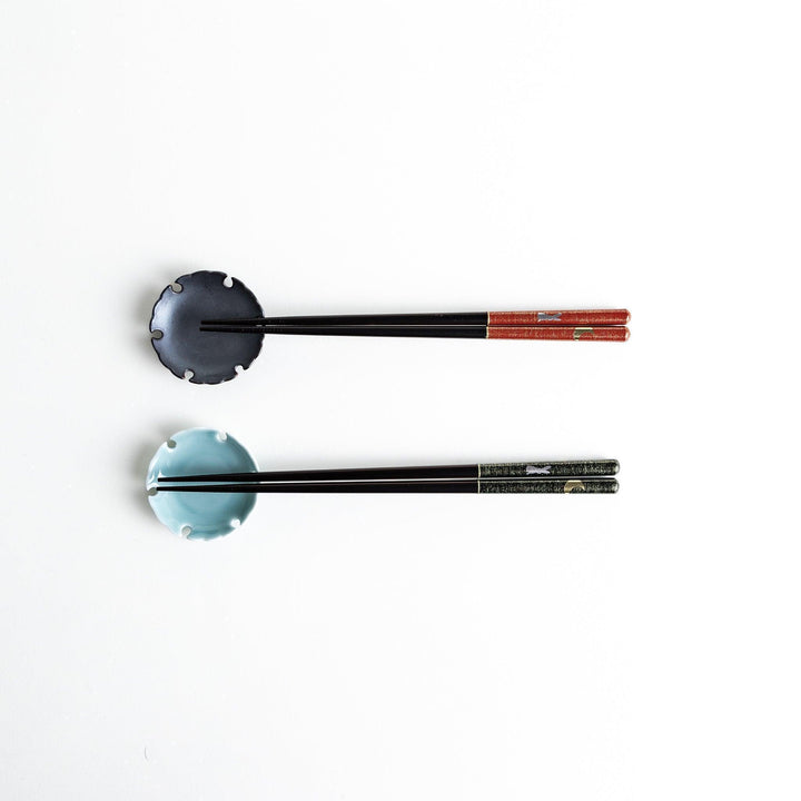 A boxed set of two pairs of chopsticks, one with a green and one with a red pattern on the handles with rabbit and moon pattern.