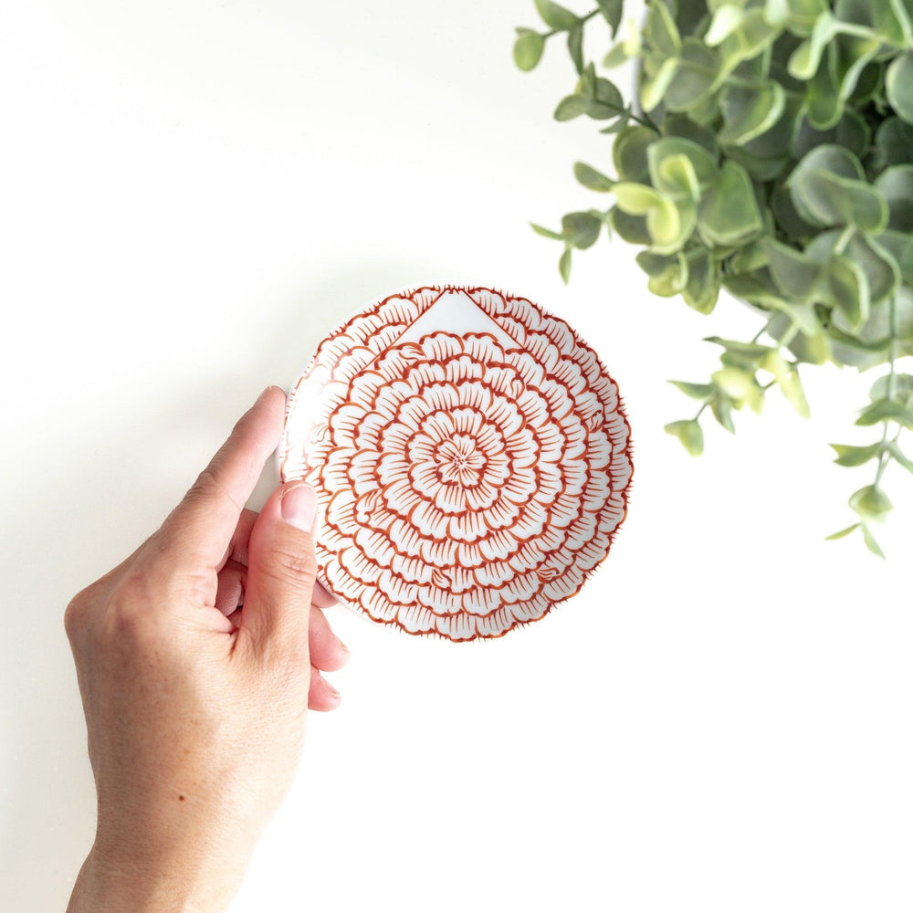 Round plate with a red chrysanthemum petal design.