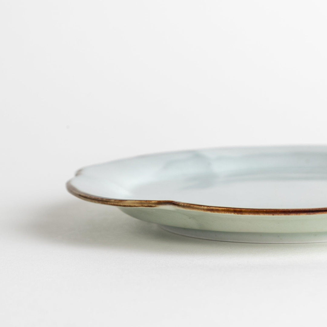 Earthy tones of olive, caramel, or off-white dessert plate, with a soft, rounded shape and subtle color variations.