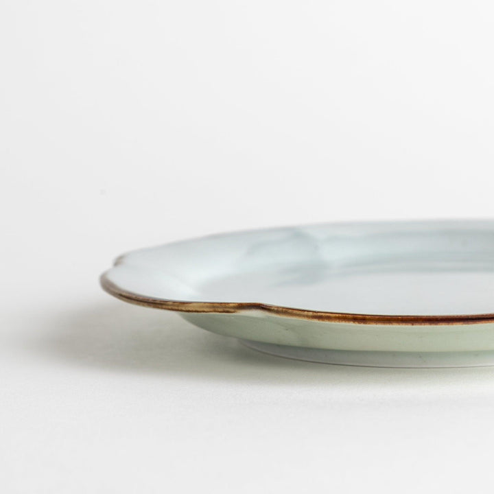 Earthy tones of olive, caramel, or off-white dessert plate, with a soft, rounded shape and subtle color variations.