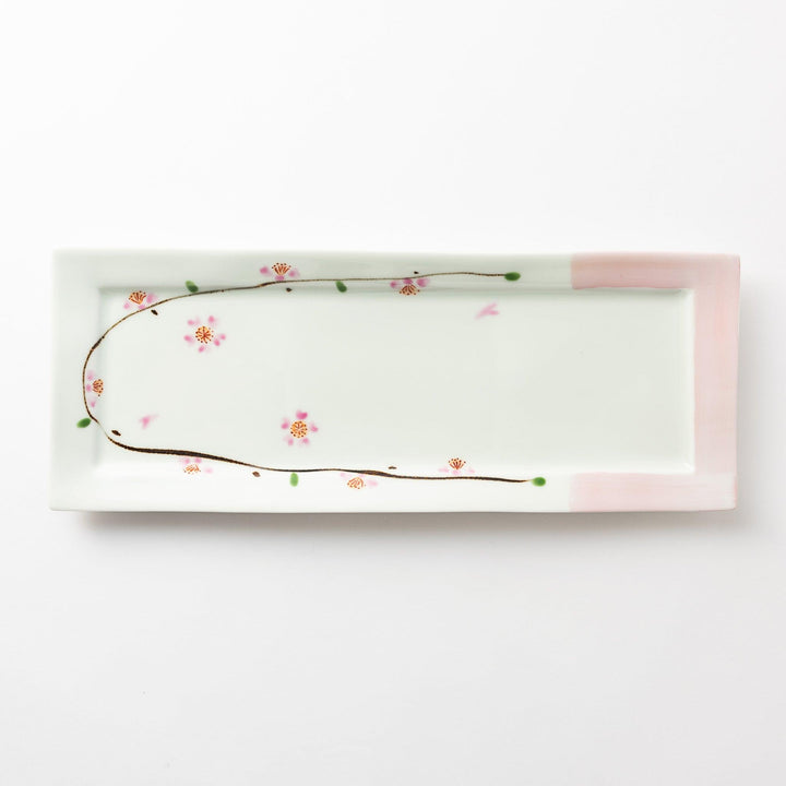 Rectangular serving plate viewed from above, featuring a delicate cherry blossom pattern along one edge with soft pink accents on the corners.
