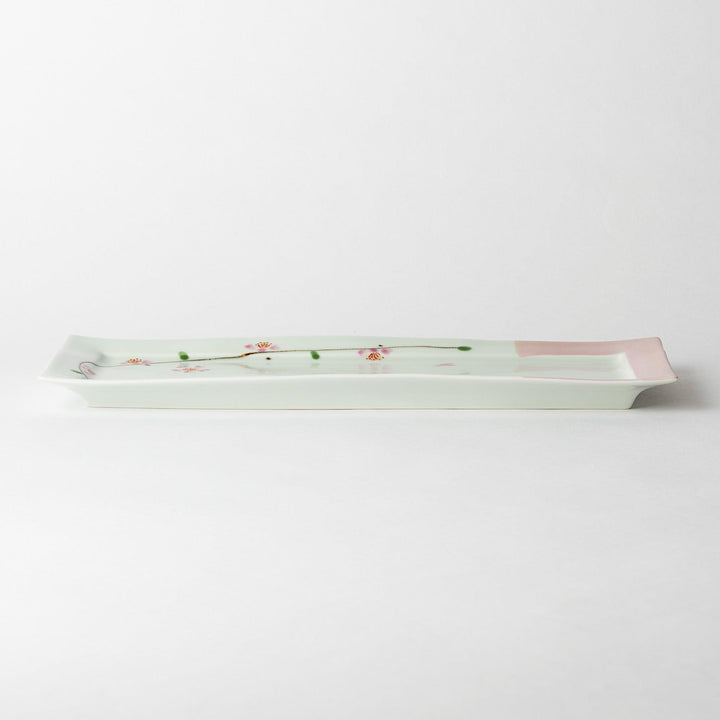 Side view of a rectangular plate featuring cherry blossoms, emphasizing its slim profile and elegant design.