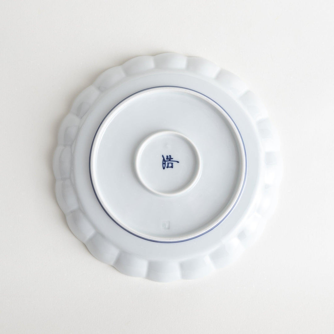 White salad plate with scalloped edges, outlined in a thin blue or red line.
